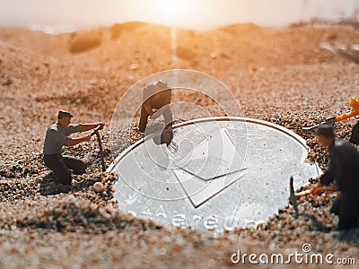 Macro miner figurines digging ground to uncover big shiny ethereum Editorial Stock Photo