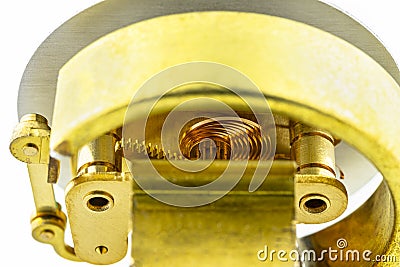 Macro photo of a bourdon tube pressure gauge mechanism with exposed copper elements, isolated on a white background. Stock Photo
