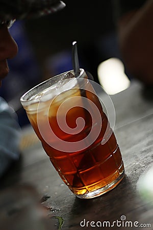 macro photo of a glass of iced tea on a black table Stock Photo