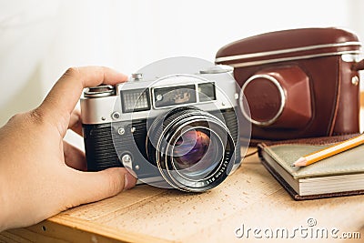 Macro photo of retro manual camera and leather case on table Stock Photo