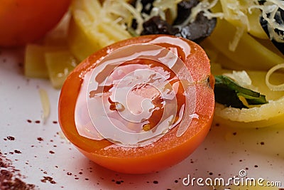 Macro photo of half tomato cherry on plate with pasta Stock Photo