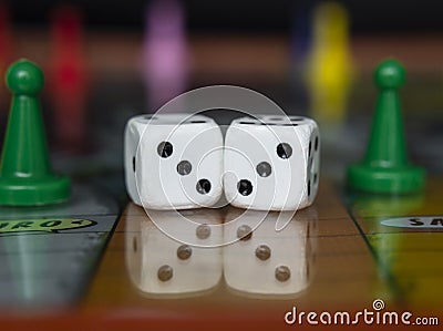 Macro photograhpy to an Old white dices with double three pair and color pawns over a board game Stock Photo