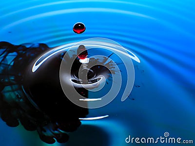 Macro photography, blue and red water drop / ink drops splash and ripples, wet, conceptual art, environmental, conservation. Stock Photo