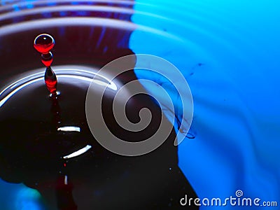 Macro photography, blue and red water drop / ink drops splash and ripples, wet, conceptual art, environmental, conservation. Stock Photo