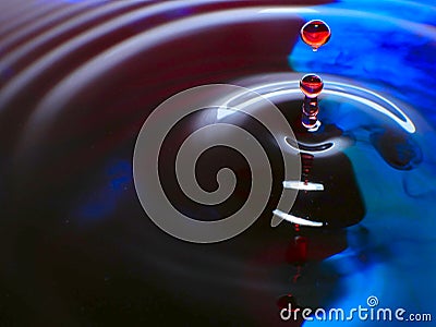 Macro photography, blue and red water drop / ink drops splash and ripples, wet, conceptual art, environmental, conservation. Stock Photo