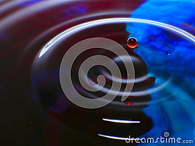 Macro photography, blue and red water drop / ink drops splash and ripples, wet, conceptual art, environmental, conservation. Stock Photo