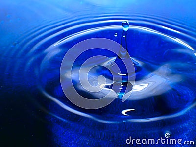 Macro photography of a dark blue water drop / ink drops splash and ripples, wet, conceptual for environmental, conservation, droug Stock Photo