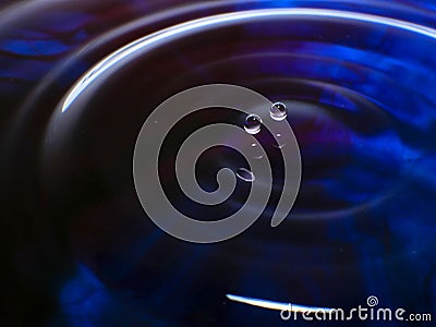 Macro photography of a dark blue water drop / ink drops splash and ripples, wet, conceptual for environmental, conservation, droug Stock Photo