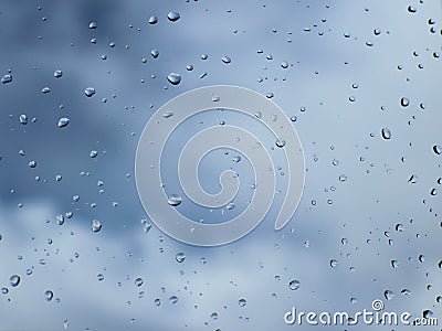 Macro photography of rain drops on the glass on a blurry background of the skyy. Texture in dark and orange tones. Stock Photo