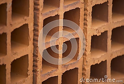 Macro of red hollow blocks arranged side by side. Interesting construction texture or background with copy space. Stock Photo