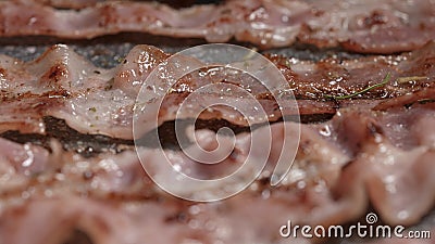 Macro ripresa del processo di cottura al pancetta. I tagli di carne appetitosi vengono fritti in una pentola. stock footage Macro ripresa del processo di cottura al pancetta. I tagli di carne appetitosi vengono fritti in una pentola. stock footage