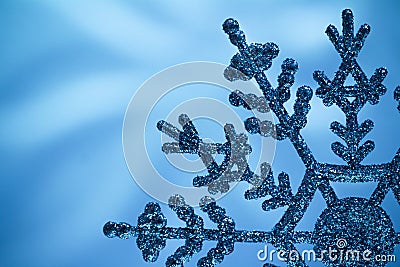 Macro shiny snowflake on blue blurred background Stock Photo