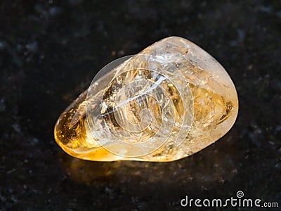 tumbled Citrine gemstone on dark background Stock Photo