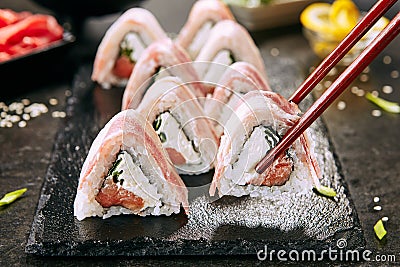 Macro Shot of Eating Bacon Uramaki Sushi Rolls in Restaurant Closeup Stock Photo