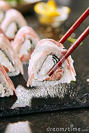 Macro Shot of Eating Bacon Uramaki Sushi Rolls in Restaurant Closeup Stock Photo