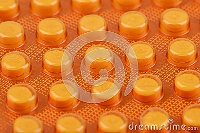 Macro shot of small pills in yellow plasticc package Stock Photo