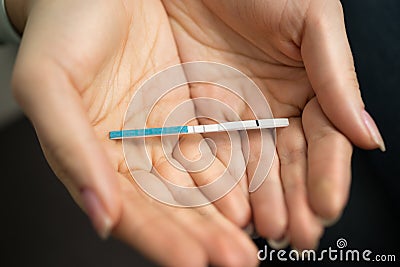 Macro shot of woman holding in hands positive pregnancy test Stock Photo