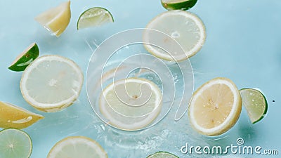 Macro of slice lemon dropping in to water with lemon and lime floating. Pabulum. Stock Photo