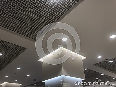 Macro Suspended Grid false ceiling with gypsum bulkhead design and column coves with indirect lighting for a lucrative design view Stock Photo