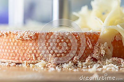 Macro of texture cheese Monk Head. Cheese with girolle knife. Shallow depth of field. Copy space. Closeup. Stock Photo