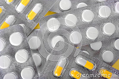 Macro of therapy supplements. Beautiful pills on a shiny background. White and orange tablets. Treatment for healing a sickness. Stock Photo