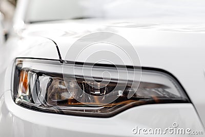 Macro view of modern white car xenon lamp headlight, bumper. Exterior of a modern car Stock Photo