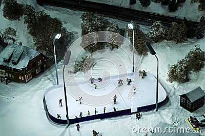 Toy railroad layout with buildings, and people on a rink. Editorial Stock Photo