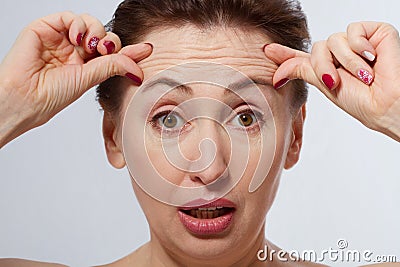 Macro Woman face with wrinkles on the forehead. Collagen and face injections concept. Menopause. Stock Photo