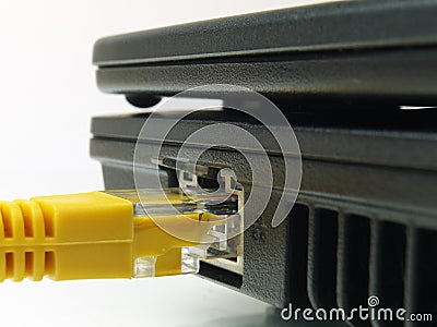 Macro of yellow twisted pair ethernet network cable connected to laptop Stock Photo