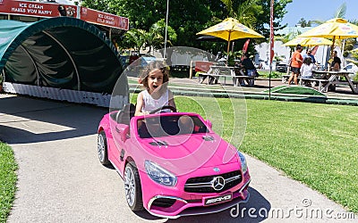 Macy in pink Mercedes battery car Editorial Stock Photo