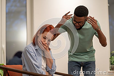 Mad angry African American man husband blaming and shaming wife at home. Domestic violence concept Stock Photo
