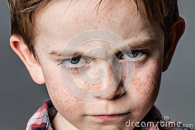 Mad little kid with furious blue eyes for childhood rebellion Stock Photo