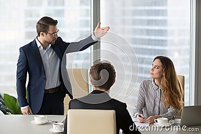 Mad male worker asking female partner leave meeting Stock Photo