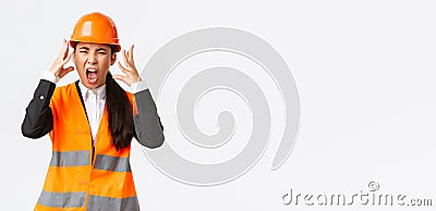 Mad and outraged asian female chief engineer, construction manager burst in rage, losing temper at employees, shouting Stock Photo