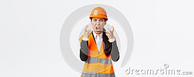 Mad and outraged asian female chief engineer, construction manager burst in rage, losing temper at employees, shouting Stock Photo