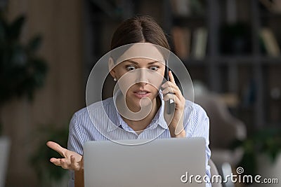 Mad woman talk on cell frustrated by computer problem Stock Photo