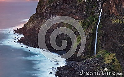 Madeira island - Dramatic sunrise over atlantic ocean with waterfall landscape from Miradouro do Veu da Noiva Stock Photo