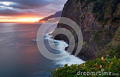 Madeira island - Dramatic sunrise over atlantic ocean with waterfall landscape from Miradouro do Veu da Noiva Stock Photo