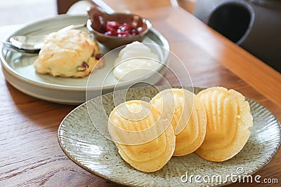 Madeleine or Madeleines and scone , cranberry scone or scone with whipped cream and berry sauce Stock Photo