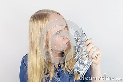 Close-up of a girl sniffing money. Madness and greed from currency. The concept of corruption and getting money at any cost. Stock Photo