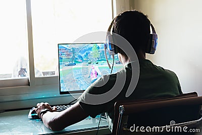 Teenager playing Fortnite video game on PC Editorial Stock Photo