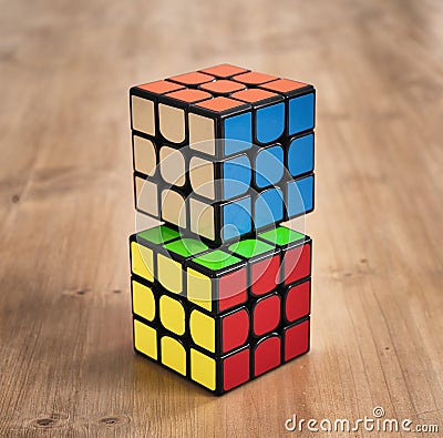 Madrid, Spain; 9 february 2019: Several Rubik cubes intelligence toys solved, in a wood table Editorial Stock Photo