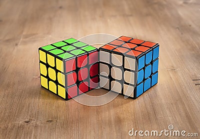 Madrid, Spain; 9 february 2019: Several Rubik cubes intelligence toys solved, in a wood table Editorial Stock Photo