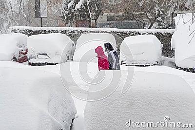 MADRID, SPAIN - JANUARY 9, 2021. Sheltered people walking on the snow-filled road. Editorial Stock Photo