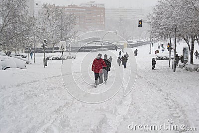 MADRID, SPAIN - JANUARY 9, 2021. Sheltered people walking on the snow-filled road. Editorial Stock Photo