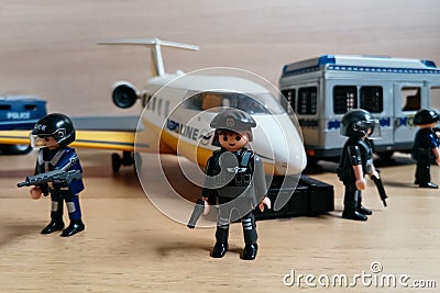 Playmobil figurines in scene representing police forces surrounding a plane. Editorial Stock Photo