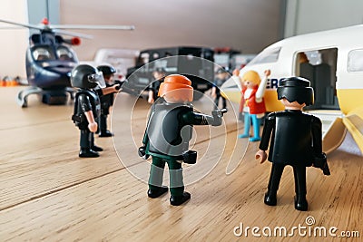 Playmobil figurines in scene representing police forces surrounding a plane. Editorial Stock Photo