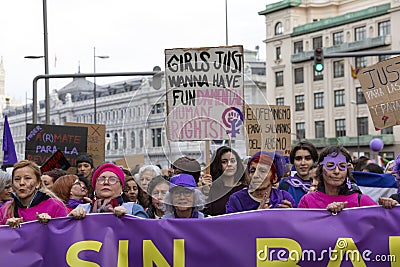 Head of the feminist march and group of protesters concentrated with a protest banner in one of the main streets of central Madrid Editorial Stock Photo