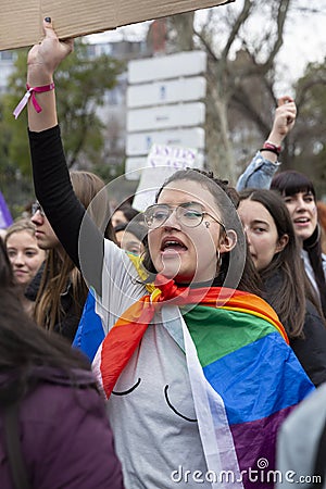 Young woman with the LGBT flag during the Women`s Day demonstration in the city center of Madrid, Spain, on March 8, 2020 Editorial Stock Photo