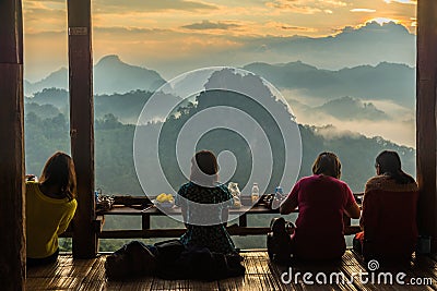 Tourists sitting in rural restuarant and having food while looking to morning view of mountain Editorial Stock Photo